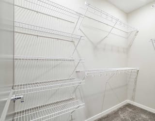 a walk-in closet with built in wire shelving