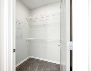 a walk-in closet with built-in shelving on two walls