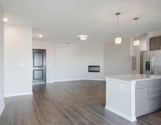 an open-concept living room and kitchen area with hard wood flooring and a fireplace