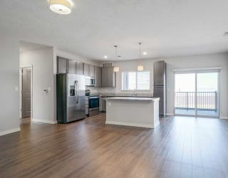 an open kitchen, dining room and living room space with luxury vinyl hardwood floors