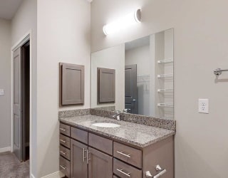 a bathroom with a large vanity sink with granite countertop and a medicine cabinet