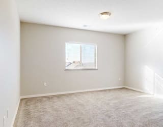a bedroom with a window and carpeting