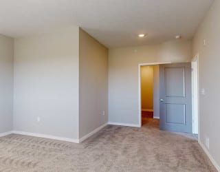 an L-shaped bedroom with an attached bathroom and walk-in closet