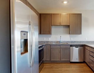 a kitchen with stainless steel appliances and grey wooden cabinets
