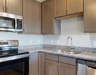 kitchen counters and cabinets, showcasing ample storage and stainless steel sink with a modern faucet