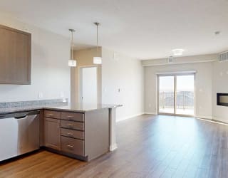 an open living room with a fireplace next to a kitchen with a peninsula countertop