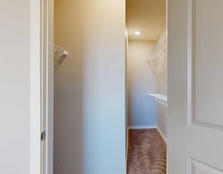 a long walk-in closet with built-in shelving for extra storage space