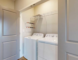a laundry room with a full-sized side-by-side washer and dryer and overhead storage