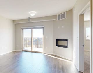 a living room with a large sliding glass door, a fireplace, and luxury vinyl hardwood flooring