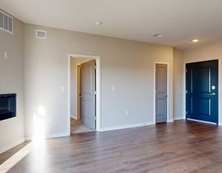 a living room with a fireplace and a door into the primary bedroom