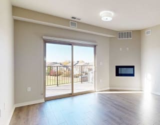 a bright living room with a large sliding glass door and a fireplace