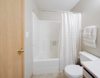 a bathroom with a shower tub combo and a toilet and a sink