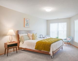 Furnished bedroom with a bed and chairs and a window