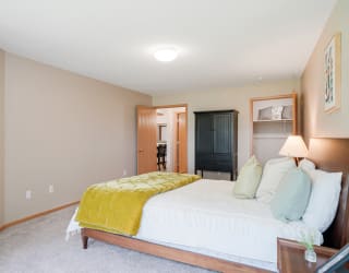 Furnished bedroom with a bed and a yellow blanket