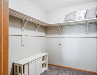 a walk in closet with shelves
