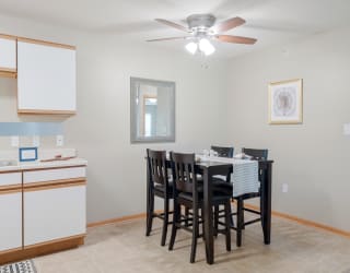 a dining room with a table and chairs and a ceiling fan