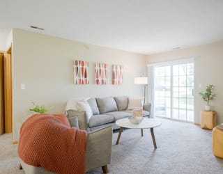 Furnished living room with a couch and a coffee table and orange accents