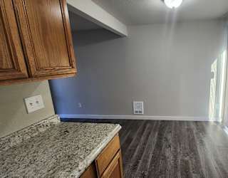a kitchen and living room with wood flooring and a window