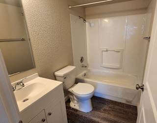 a bathroom with a toilet and a tub and a sink