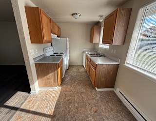 A kitchen with wooden cabinets and a white refrigerator.