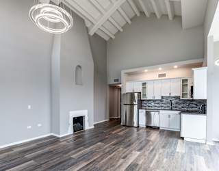 a living room with a fireplace and a kitchen