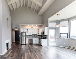 a living room with a kitchen and a large window