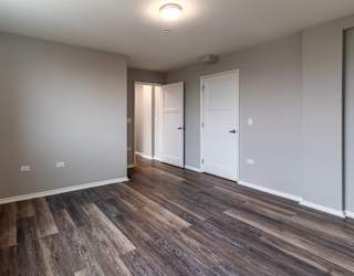 a living room with wood flooring and white walls and doors