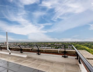 a balcony with a view of a city and a blue sky