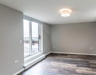 a living room with a large window and wood flooring