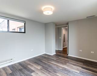 a living room with wood flooring and a large window