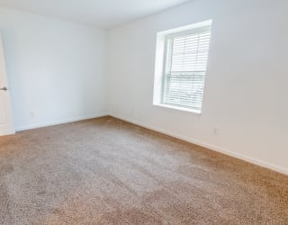 an empty room with carpet and a window