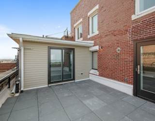 a patio with a brick wall and glass doors