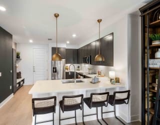 a kitchen with a large island with four chairs