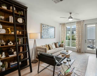 a living room with a couch and a ceiling fan