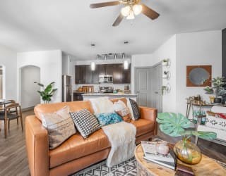 a living room with white walls and a brown leather couch