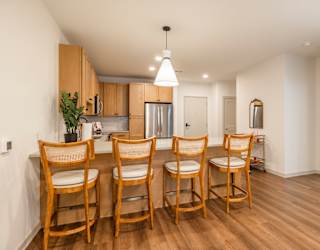 A kitchen with wooden chairs and a table.