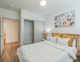 A bedroom with a large bed and a painting on the wall.