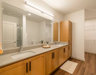 A bathroom with two sinks and wooden cabinets.