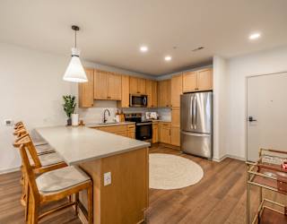 A kitchen with wooden cabinets and a white island.