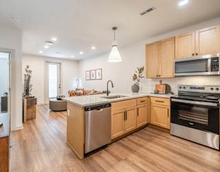 A modern kitchen with wooden cabinets and stainless steel appliances.
