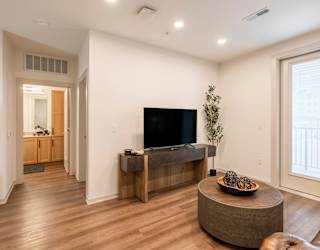 A living room with a flat screen TV and a wooden cabinet.