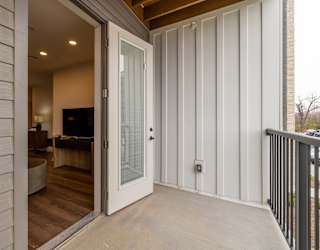 A white door is open to a room with a wooden floor.