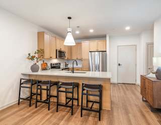 A kitchen with wooden floors and a white counter top.