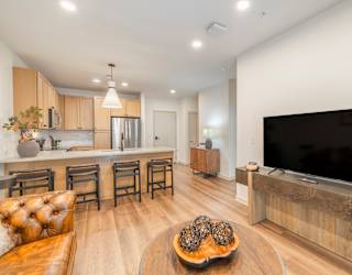 A modern living room with a brown leather couch and a wooden coffee table.
