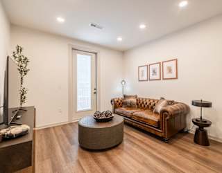 A living room with a brown couch and a wooden coffee table.