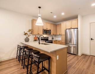A kitchen with a white counter top and wooden cabinets.
