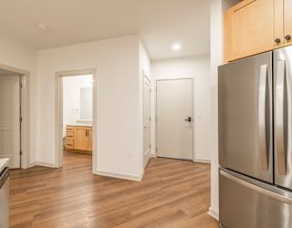 A kitchen with a refrigerator on the right side.