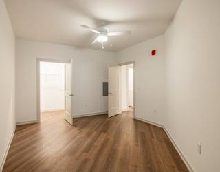 A room with wooden floors and a ceiling fan.