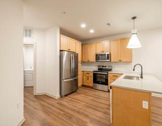A kitchen with wooden cabinets and a white counter.