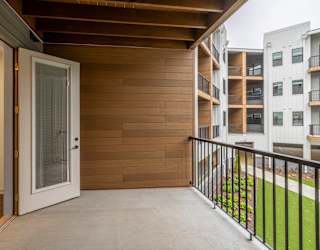 A balcony with a white door and a black railing.
